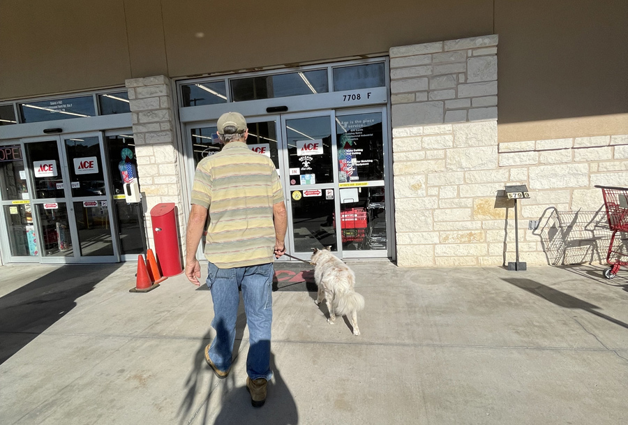 man and dog walking in Ace Hardware